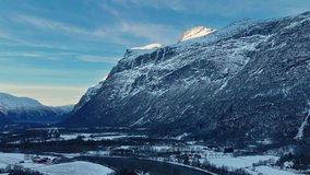 This drone footage of Oppdal, Norway, winter. Majestic snow capped mountains tower over a tranquil valley dotted with charming houses and a winding river, all bathed in the soft glow of sunlight. - Powered by Shutterstock - Get 15% off with code: PIKWIZARD15