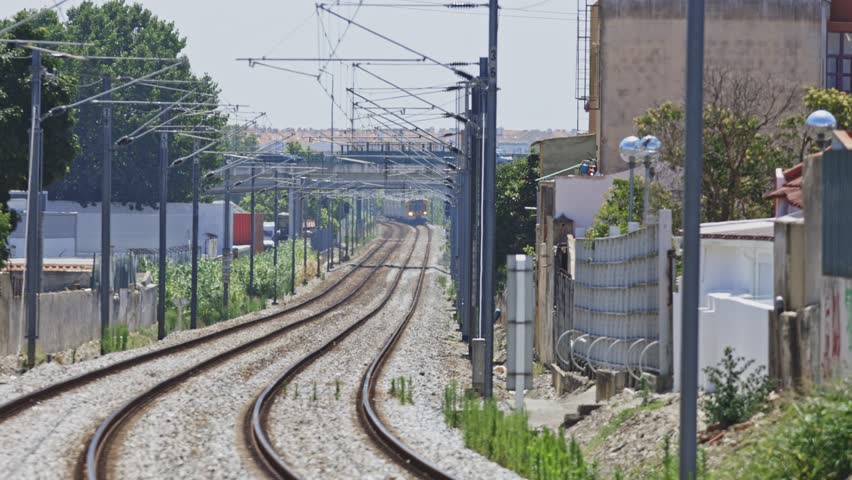 Commuter train approaching on electrified railway tracks