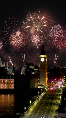 Elevated view of the Big Ben clocktower and Westminster Bridge in London, England, during night time with fireworks for new years