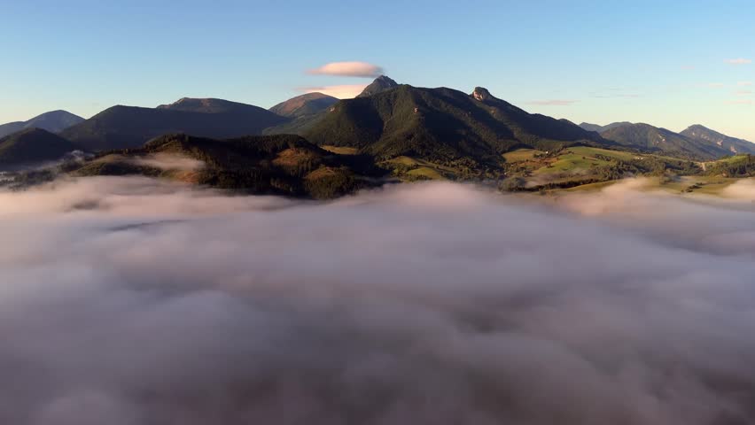 Aerial video of a mountain valley with a cloud inversion in the morning