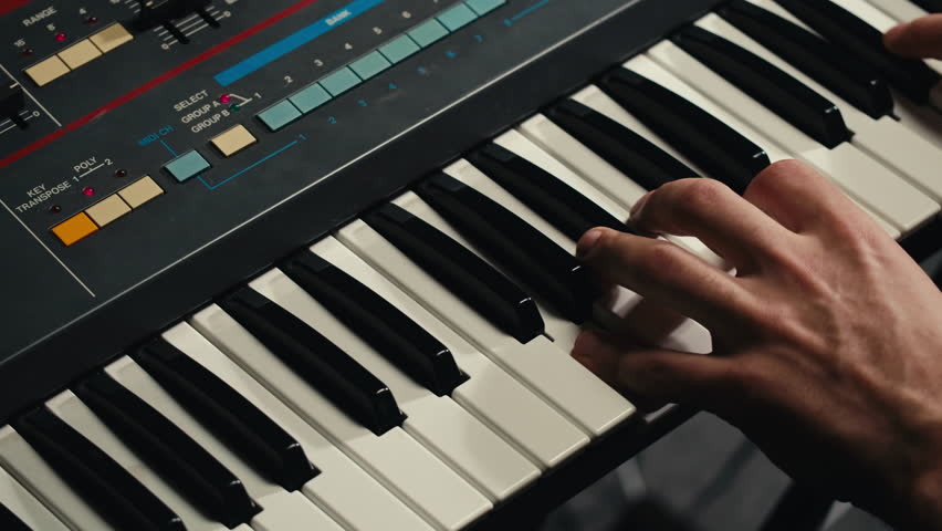 Playing piano vintage retro synthesizer. Close up of man hands playing jazz on the piano. Fingers on the piano, vintage colors. A very close look at a jazz pianist hands. Man playing the piano, close