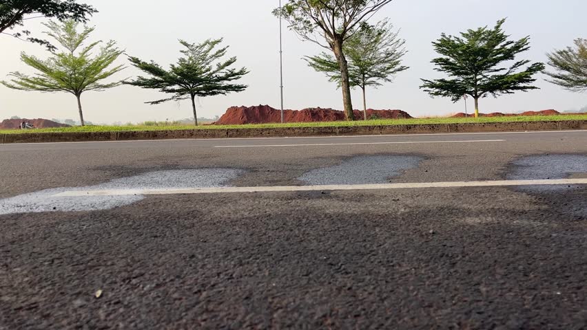 Low angle view of motorcycle and bicycle tires moving on an asphalt road