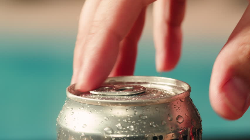 Opening soda or beer can, macro close up of can pull tab opening, watering refreshment, hand open lemonade or juice.