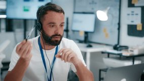 Professional Male Call Center Operator Working in a Modern Office, Providing Customer Support, Consulting Clients, Contacting Customers, Help, and Managing Sales Conversation with CRM System Helpline. - Powered by Shutterstock - Get 15% off with code: PIKWIZARD15