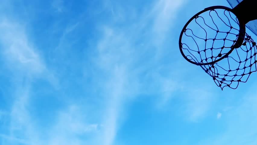 Slow motion of a basketball going into the hoop. Silhouette basketball hitting the hoop accurately, goal concept