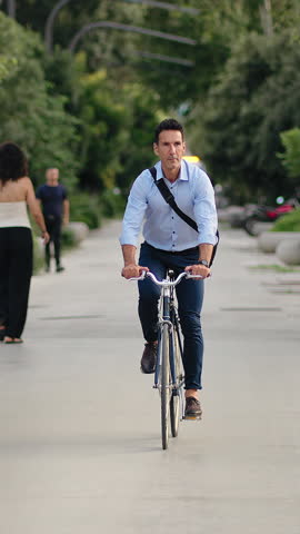 Elegant Business man commuting to work by bicycle in urban park