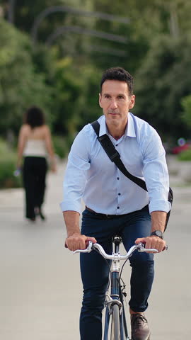 Elegant Business man commuting to work by bicycle in urban park