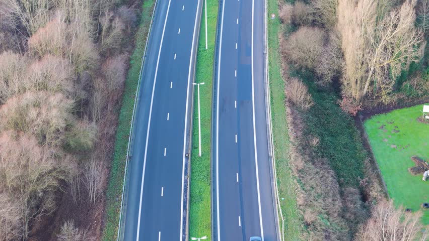 countryside road highway melle belgium green patch middle surrounded by cover trees both sides scenic urban area infrastructure journey aerial view