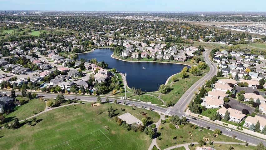 4K aerial view of Briarwood in Saskatoon during autumn, showcasing colorful trees, upscale homes, and parks in this established southeast neighborhood.
