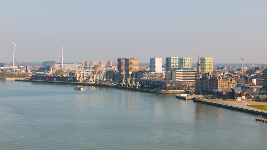 skyline antwerp belgium boats scheldt river historical buildings colorful distant windmills scenic urban area infrastructure journey aerial view