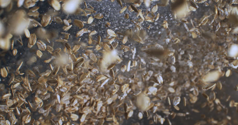 Slow Motion Explosion Of Golden Oat Grains Floating In Air Against Dark Background Creating Dynamic Organic Texture at 1000 fps.