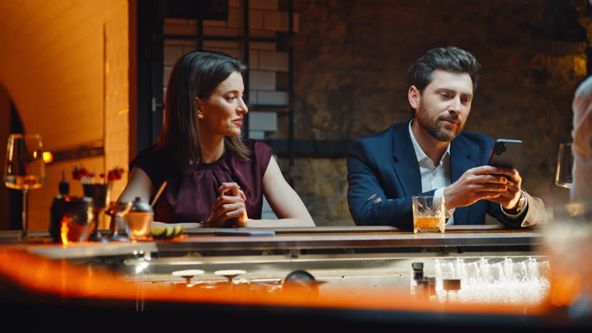 Man woman talking bar counter at evening closeup. Two strangers flirting night club ordering drinks. Elegant lady taking wineglass asking gentleman cozy restaurant atmosphere. Informal communication