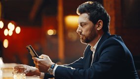 Stylish guy waiting bar alone at cozy lobby sipping whiskey checking phone closeup. Confident lady walking evening lounge joining man at counter. Two strangers meeting in cafe enjoying casual chat - Powered by Shutterstock - Get 15% off with code: PIKWIZARD15