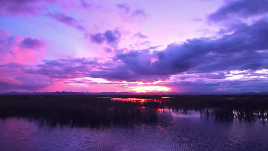 Dramatic sunset over a tranquil lake with vibrant colors