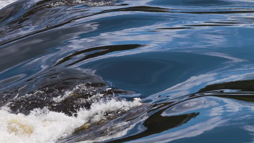 Close up view of the fast flowing tannic waters of the Gatineau river rapids.