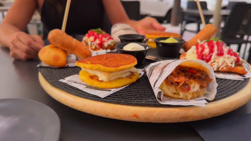 Assorted platter with traditional Venezuelan dishes such as empanadas, tequeños, cachapas and patacones served at a restaurant.