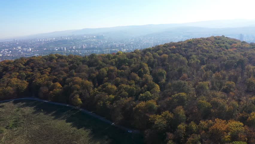 Aerial view of forest surrounding city. Cluj Napoca, Romania by drone