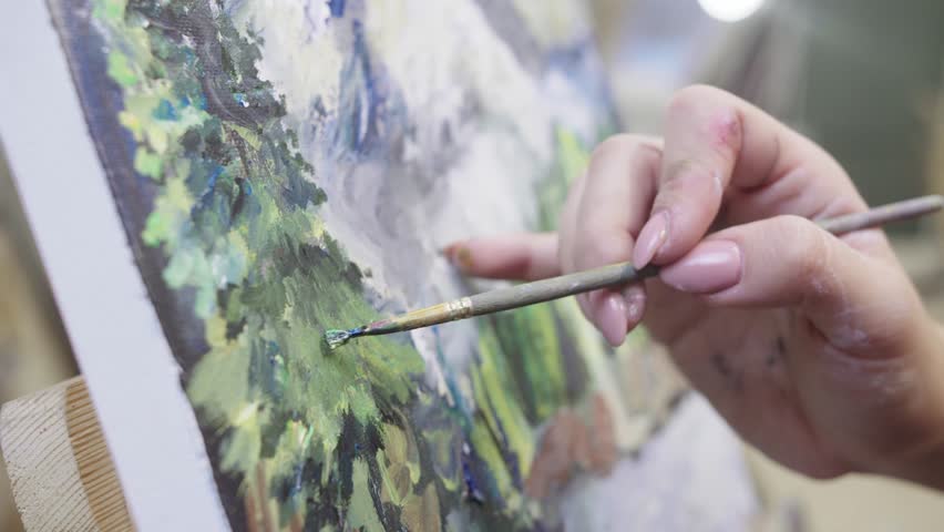 Female artist hand painting mountain landscape