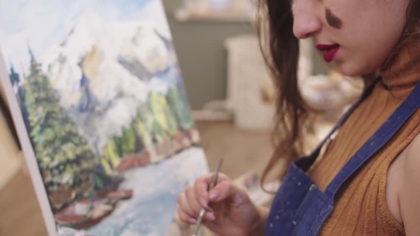 Creative female artist painting mountain landscape