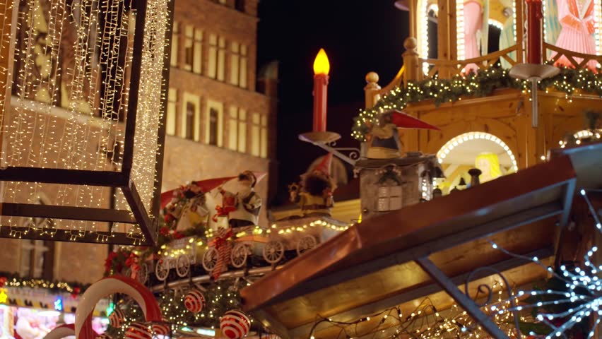 Christmas fair at night with illuminated gnome figures riding on toy train, festive lights and holiday atmosphere at night city. Christmas market in Wroclaw, Poland