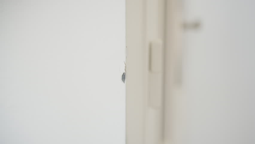 Female Hand Touching Peeled Paint On A Corner Wall. Close-up Shot