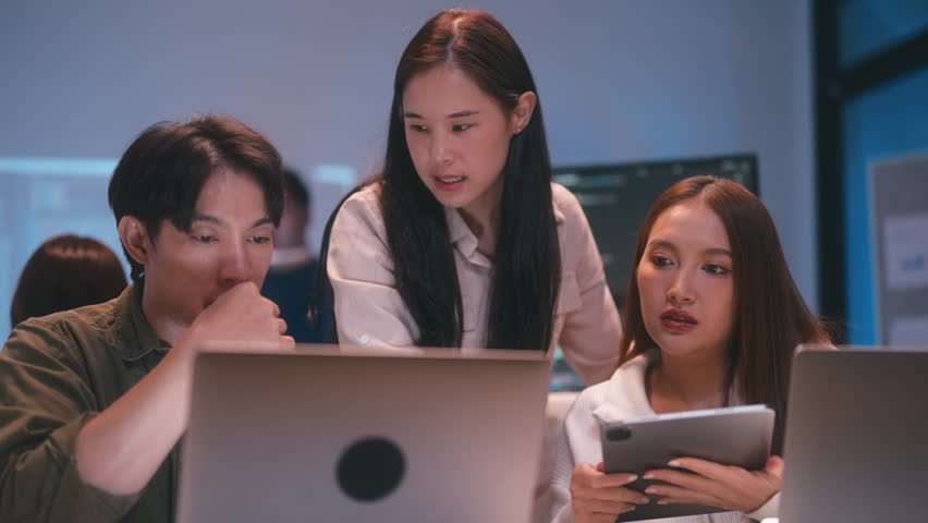 Young Asian business people working late into the night in the office, meeting, brainstorming, presentation working about coding