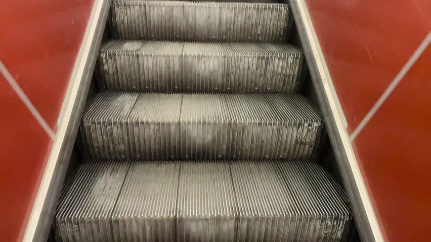Imagine looking down at an escalator from above, taking in the steps that move continuously alongside the surrounding walls of the area