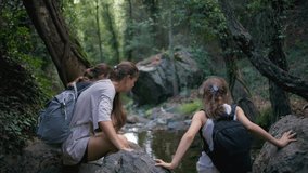 Family hiking together near a forest lake. Mom and daughters actively spend time in the natural landscape, walking through the forest. - Powered by Shutterstock - Get 15% off with code: PIKWIZARD15