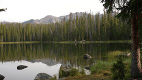 Pristine Alpine Lake and Pine Forest Under Snow Capped Mountain Hills, Panorama - Powered by Shutterstock - Get 15% off with code: PIKWIZARD15