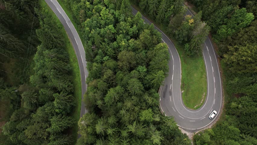 Cars driving in Alpine pass, Aerial birds eye view of winding mountain road in the Austrian Alps with dramatic alpine scenery