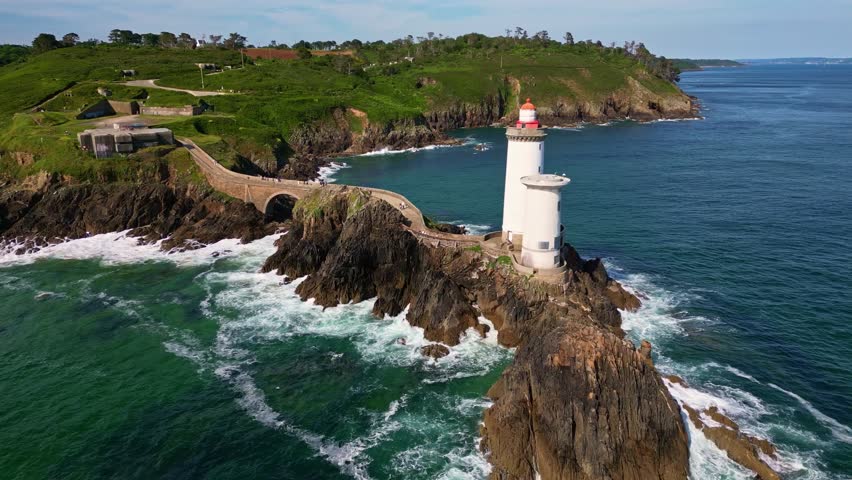 Drone flying towards Petit Minou Lighthouse on rocky islet, Brittany, France. Aerial forward