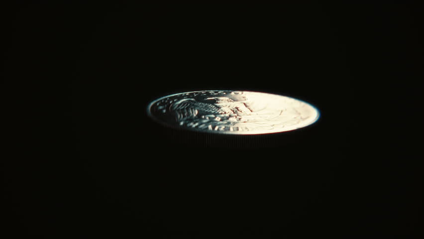 Seamless loop of a United States quarter dollar coin flipping on a dark background, symbolizing gambling, luck, finance, and decision making.