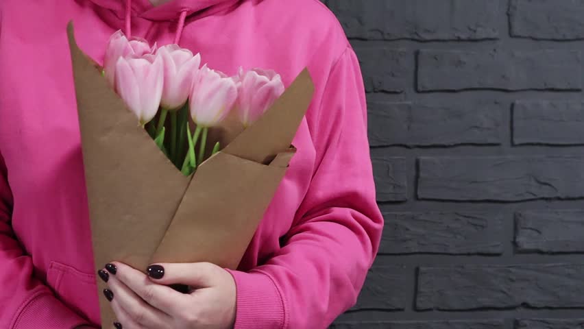 girl with a bouquet of tulips in her hands. A gift on a special day. Video postcard