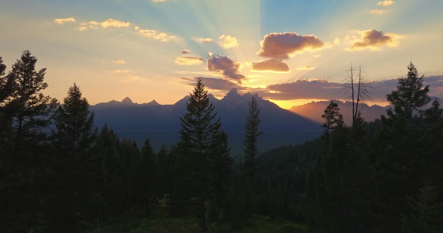Scenic sunset over Tetons, Wyoming, with trees and mountains, peace