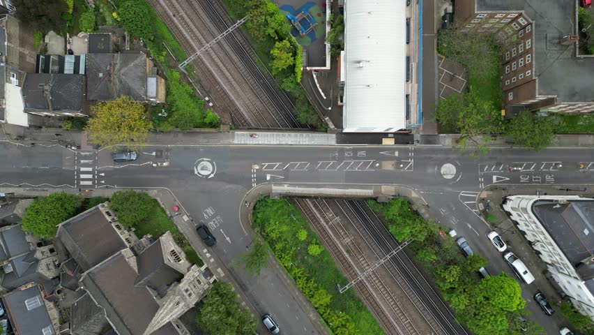 Drone flying over a London suburban neighborhood with cars driving on the road, filmed in 4K 60FPS. Perfect for calm, urban lifestyle, and travel projects.