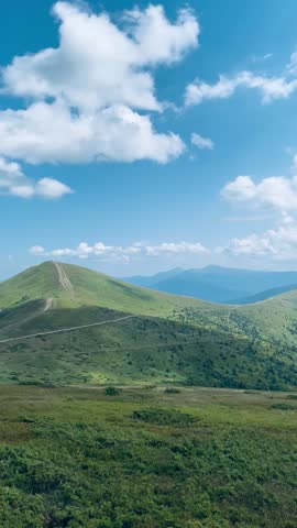 Green Carpathians under blue sky and clouds