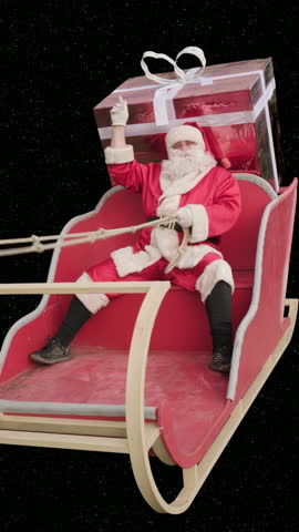 Cheerful Santa Claus dancing rides on sleigh with huge gift box on background of starry sky, vertical video