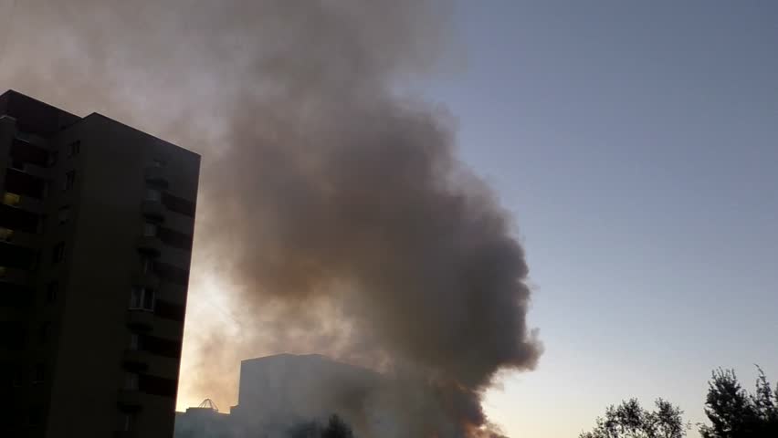 Smoke from the fire among the houses. Large fume of a conflagration the sky of a residential area.