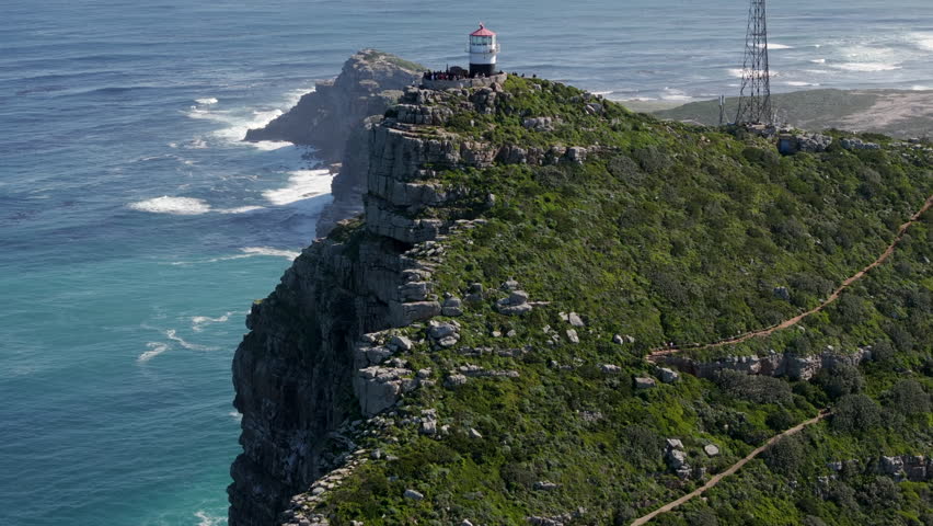 Aerial jib shot flying over the Old Lighthouse at Cape Point and revealing the iconic Cape of Good Hope at Cape Peninsula, near Cape Town, South Africa. 