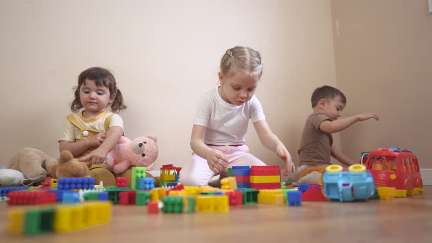 Two children playing with blocks. Group of children playing with toys in a kindergarten. Constructors build a kindergarten together. Two kids engaging with building lifestyle blocks.
