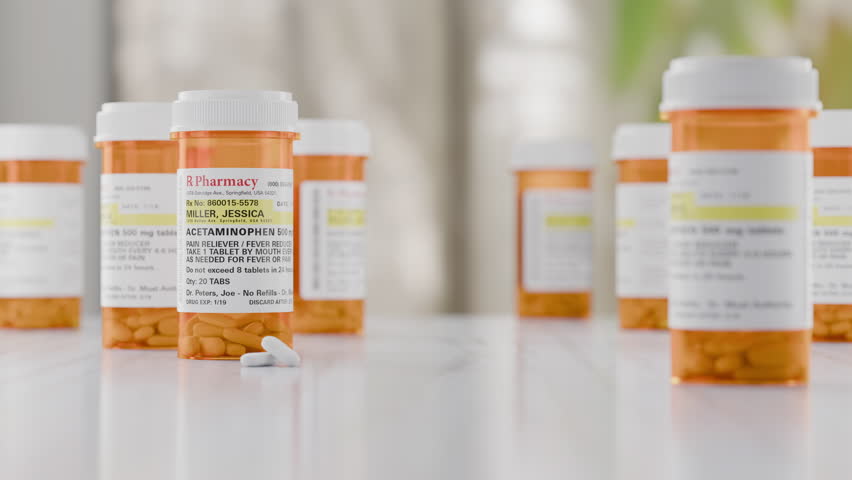 Dolly Camera Movement Focus on Acetaminophen Prescription Medicine Bottles and Pills Resting on Bathroom Countertop. Label is non-proprietary, fictional, made specifically for the stock photo industry