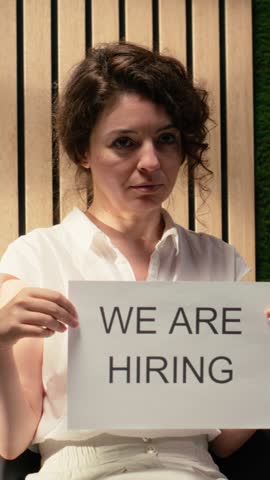 Vertical Video Confident HR professional showcases announcement for open roles in the company, promoting workplace development, onboarding and search for ambitious new talent. Hiring ad. Camera B.