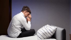 christian Young man praying rosary sitting on bed - Powered by Shutterstock - Get 15% off with code: PIKWIZARD15