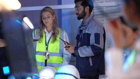In a modern factory, a male supervisor with a walkie-talkie instructs a female worker in a high-visibility vest as they collaborate on the production line, ensuring safety and efficiency. - Powered by Shutterstock - Get 15% off with code: PIKWIZARD15