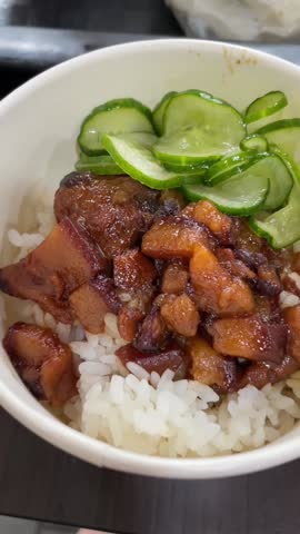 A bowl of braised pork rice with sides of cucumber and radish. It is also called Lu Rou Fan. 