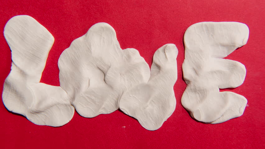 Claymation or clay stop-motion of a heart-shaped turn into the word “love” and stretched to fill the frame