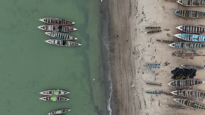 Aerial top down of traditional wooden fisherman boat on the beach of Joal Faidouth, Senegal