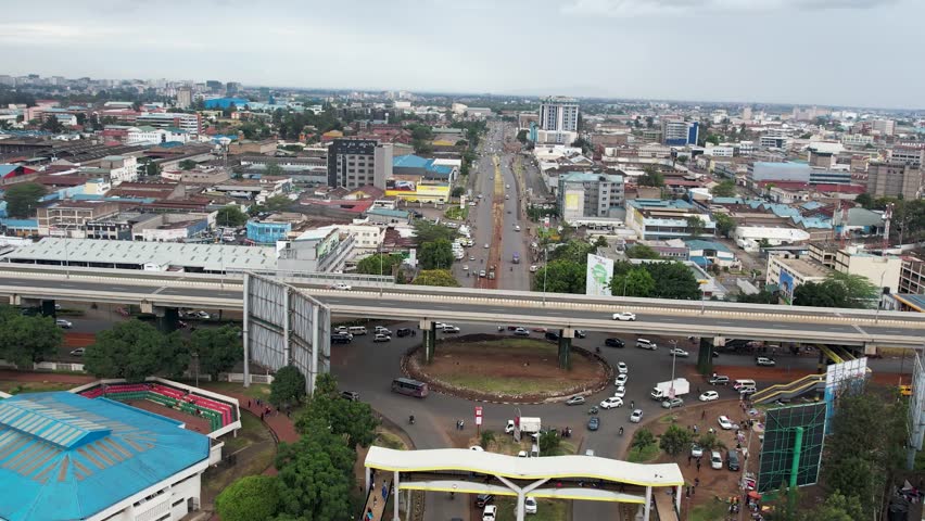A beautiful aerial drone footage of the city of Nairobi, Kenya, showcasing the bustling urban office spaces, modern residential areas, the Nairobi Expressway, and Waiyaki Way. Captured during the day.