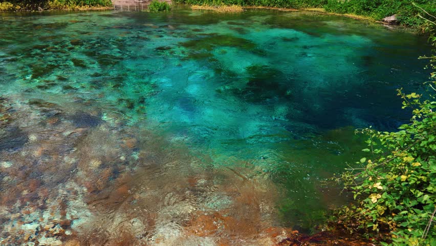 The Blue Eye in Albania with clear turquoise water and green nature surroundings. Syri i Kaltër