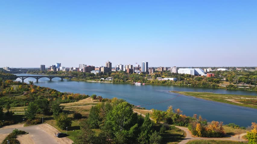 Aerial establishing shows Saskatoon downtown bustling with bridges and river